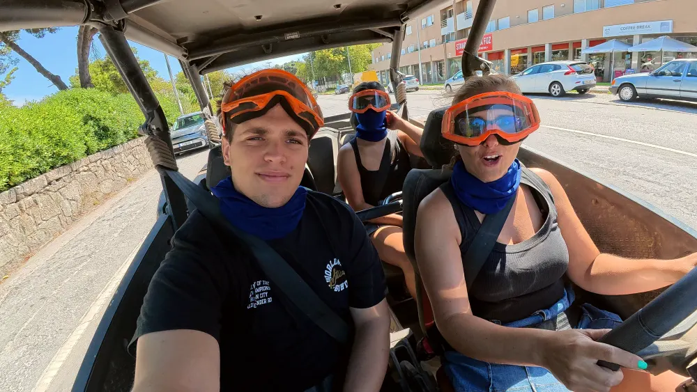 Smiling family in the buggy with orange goggles, setting off