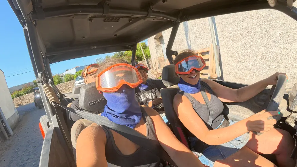 Dusty crew in goggles riding through the village